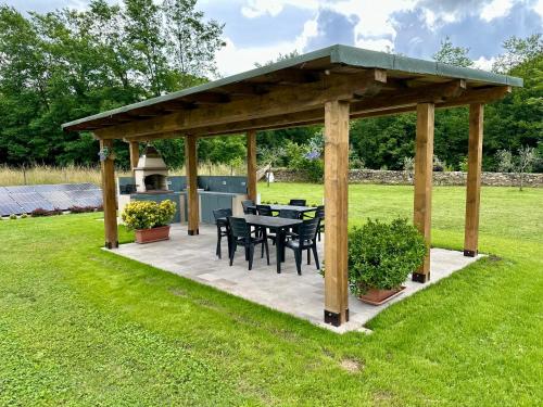 a wooden pavilion with a table and chairs in a field at Villa Amanda in Scorcetoli