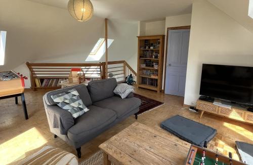 a living room with a couch and a flat screen tv at Hent Ar Mor - Elégante Demeure Trébeurden in Trébeurden