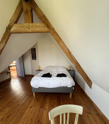 a bedroom with a bed and a chair in a attic at Hent Ar Mor - Elégante Demeure Trébeurden in Trébeurden