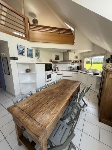 a large kitchen with a wooden table and chairs at Hent Ar Mor - Elégante Demeure Trébeurden in Trébeurden