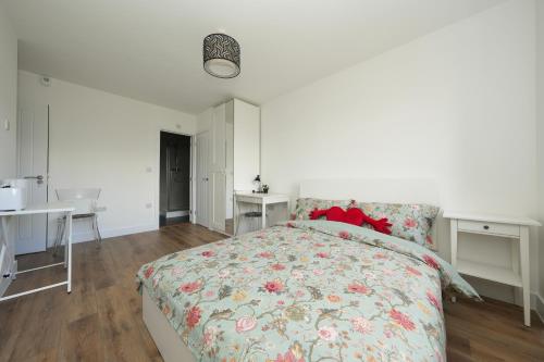 a bedroom with a bed and two desks and a table at Derwent Avenue self-contained apartments in Headington in Oxford