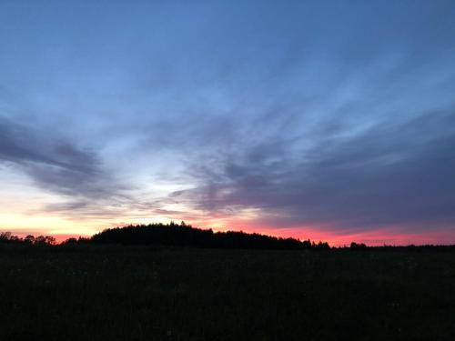 a sunset in a field with a sky at Grudza83 Bikepoint in Mirsk