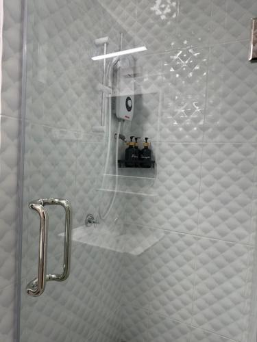 a shower with a glass door in a bathroom at Aurora Country Home in Sandakan