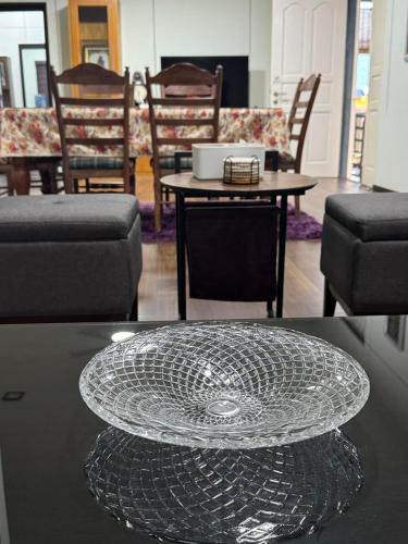 a glass plate on a table in a room with chairs at Aurora Country Home in Sandakan