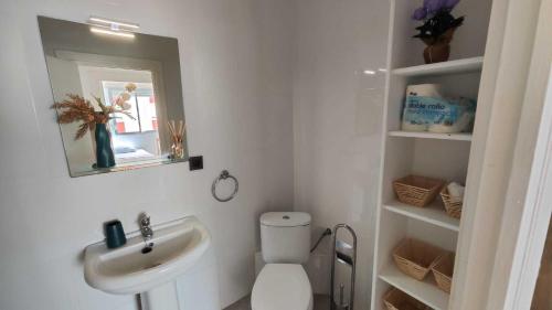 a bathroom with a toilet and a sink and a mirror at Tarifa Ocean Side Tu espacio de descanso in Tarifa