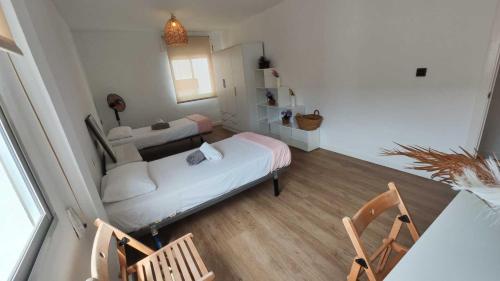 a room with two beds and a table and chairs at Tarifa Ocean Side Tu espacio de descanso in Tarifa