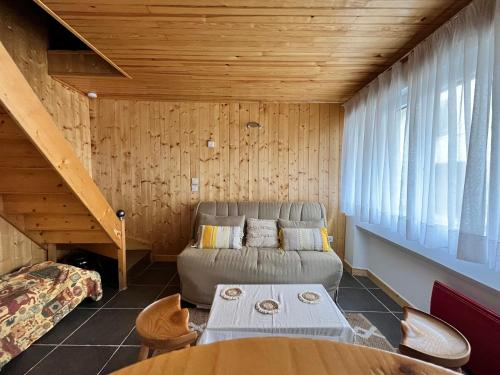 un salon avec un canapé et une table dans l'établissement Charmant gite esprit chalet, à Saint-Nazaire-le-Désert