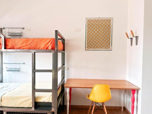 a desk and bunk beds in a room with a desk and a chair at Ostello Bello Milano Centrale in Milan