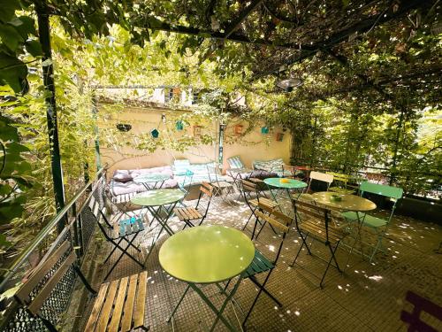 a patio with tables and chairs and a couch at Ostello Bello Milano Centrale in Milan