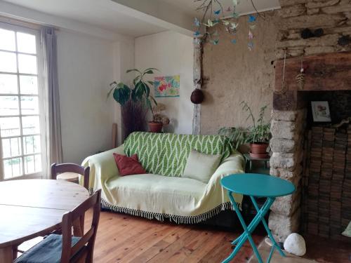 un salon avec un canapé et une table dans l'établissement Les oiseaux de passage, à Uzerche