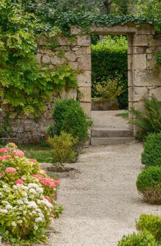 an entrance to a garden with pink and white flowers at Clos Marcamps - Teritoria in Prignac-et-Marcamps