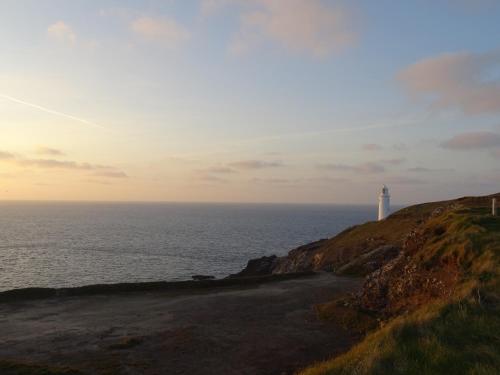 a lighthouse sitting on top of a hill next to the ocean at Tidal Heights in Padstow