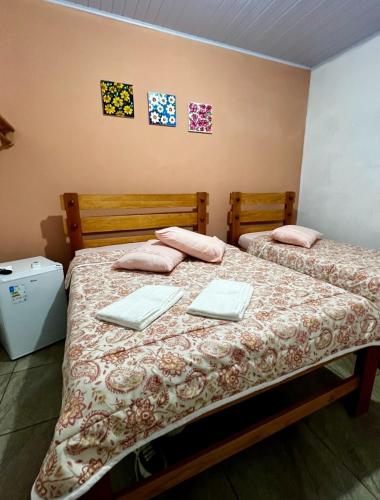 two beds in a room with two laptops on them at pousada vila das oliveiras in Pirenópolis