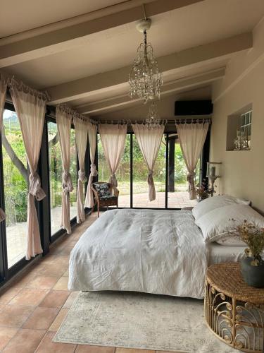 une chambre avec un grand lit et de grandes fenêtres dans l'établissement Maison de vacances à Cassis, à Cassis