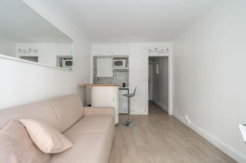 un salon avec un canapé et une cuisine dans l'établissement Bel appartement Proche Trocadéro, à Paris