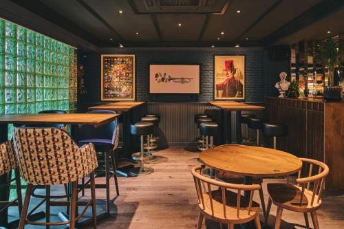 a bar with tables and chairs in a room at Royal National Hotel in London