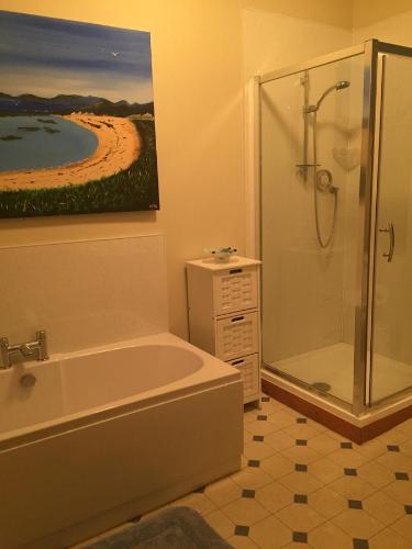 a bathroom with a tub and a shower and a painting at Grant Arms Hotel in Cullen