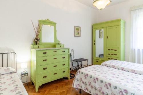 a bedroom with two beds and a dresser with a mirror at Seaview Camaiore in Camaiore