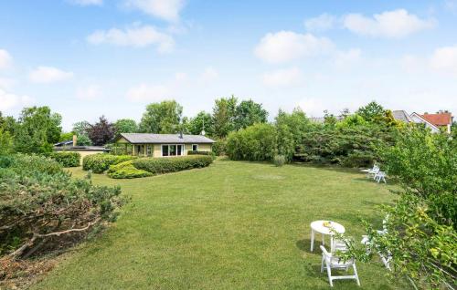 a yard with two white chairs and a house at Lovely Home In Slagelse With Kitchen in Slagelse