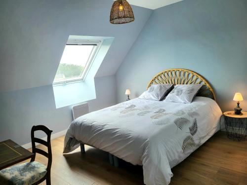 une chambre avec un lit avec des draps blancs et une fenêtre dans l'établissement Villa bord de mer La Mielle, à Créances