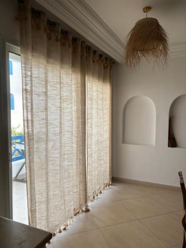 a room with sheer curtains and a large window at Hekma By El kateb in Fafou