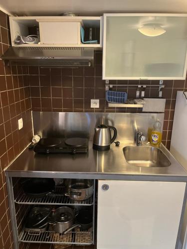 une petite cuisine avec un évier et une cuisinière dans l'établissement Maisonnette de 34m2 proche de la Gare, à Houilles