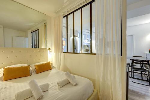 une chambre avec un grand lit avec des oreillers jaunes dans l'établissement 2 bedroom in the heart of Le Marais, à Paris