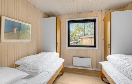 two beds in a room with a window at Brincken in Vejers Strand