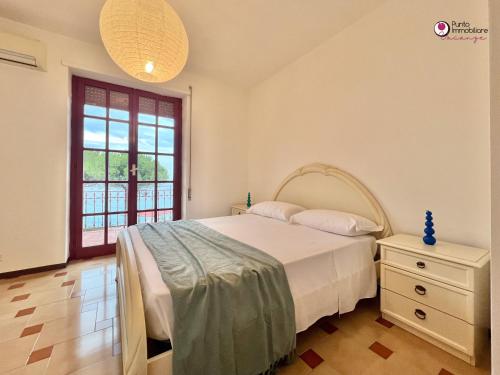 a bedroom with a bed and a window at Villa Nella - WelcHome in Marina di San Vito