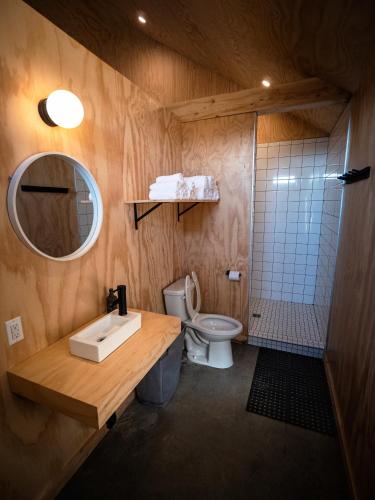 a bathroom with a sink and a toilet and a mirror at ÈST Éco-cabines in Nouvelle