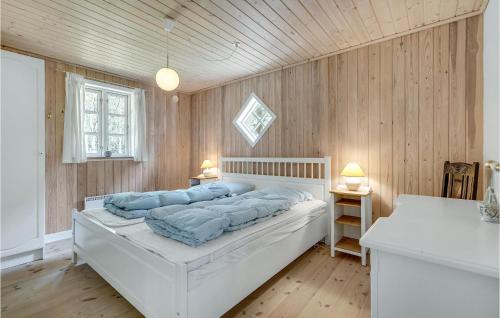 a bedroom with a bed with blue pillows on it at Stunning Home In Blåvand With Wifi in Ho