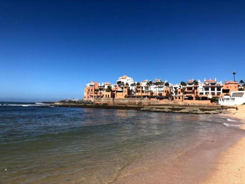 a view of a beach with buildings and the water at Shems Bouznika kettani in Bouznika