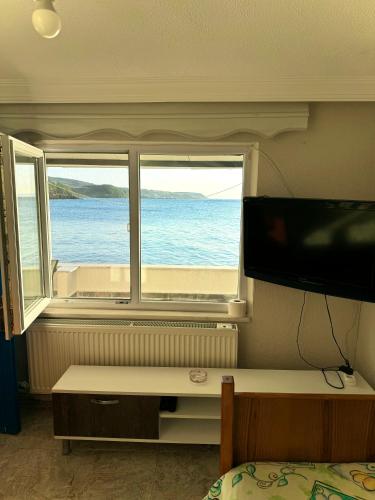 1 dormitorio con vistas al océano desde una ventana en A peaceful holiday house in nature by the sea, en Lapseki