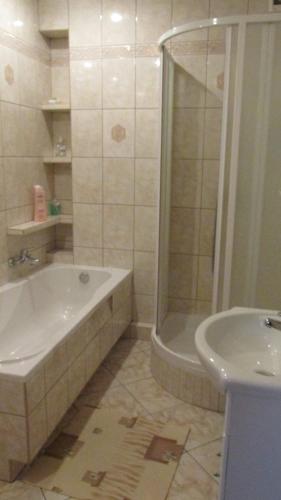a bathroom with a tub and a shower and a sink at Zajazd U Renaty in Poraj