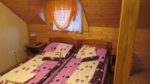two twin beds in a room with a window at Zajazd U Renaty in Poraj