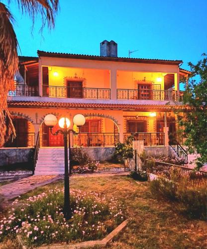 a large house with a street light in front of it at Villa Apartment with 3 bedrooms in Polýkastron