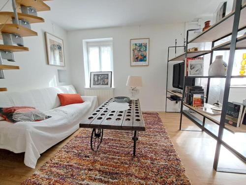un salon avec un canapé blanc et une table basse dans l'établissement L'atelier, à Ternant