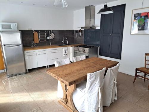 - une cuisine avec une table en bois dans l'établissement L'atelier, à Ternant
