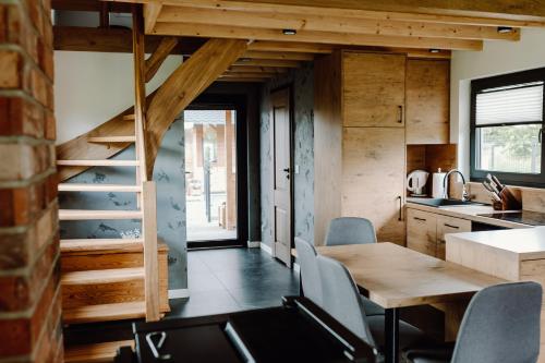 a kitchen and dining room with a wooden table and chairs at Regielskie Chaty in Regiel