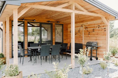 a wooden pavilion with a table and chairs on a patio at Regielskie Chaty in Regiel