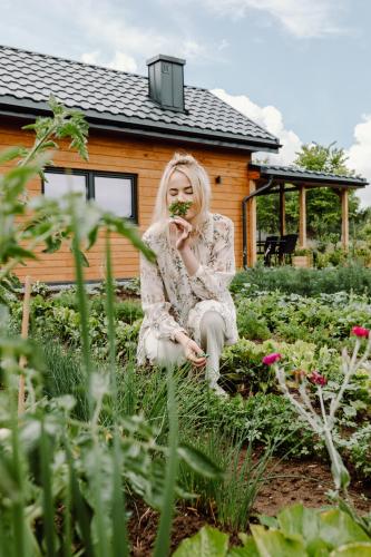 a woman sitting in the grass in a garden at Regielskie Chaty in Regiel