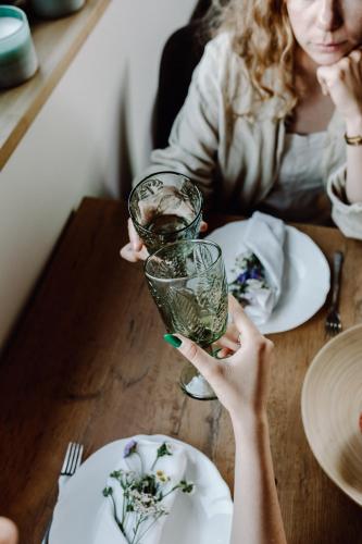 a woman holding up a glass on a table at Regielskie Chaty in Regiel