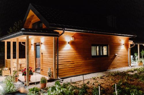 a small wooden house with a front porch at night at Regielskie Chaty in Regiel