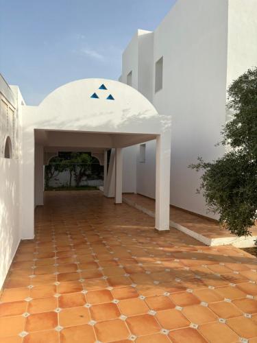 an entrance to a white building with a pavilion at Hekma by El kateb in Fafou