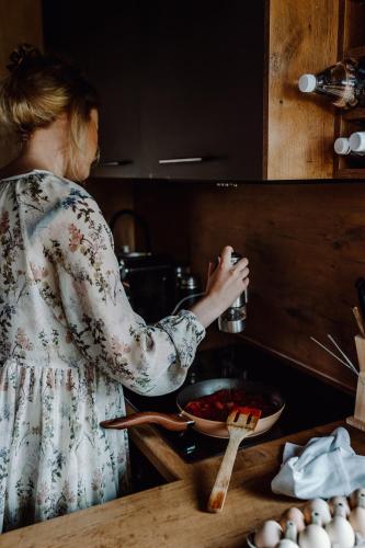 a woman standing in a kitchen preparing food at Regielskie Chaty in Regiel