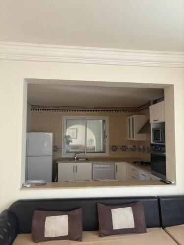 a large kitchen with white cabinets and a couch at Hekma by El kateb in Fafou