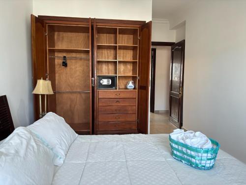 a bedroom with a bed and a wooden closet at MARINA SMIR - Beach Apartment in Marina Smir