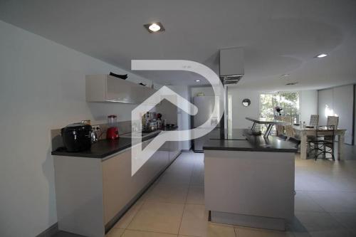 une cuisine avec des comptoirs noirs et une salle à manger dans l'établissement INTRA MUROS - Appartement, à Aigues-Mortes