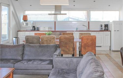 a living room with a couch and a table with chairs at Vrij-Uitzicht in Slootdorp