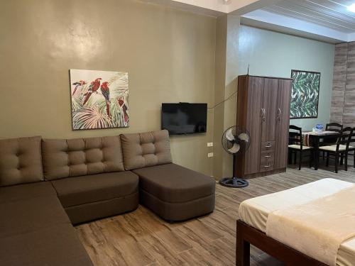 a living room with a couch and a tv at Pook ni Urduja Resort 